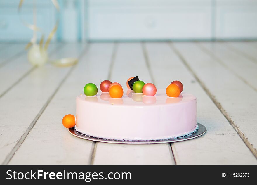 Pink Mousse Cake With Colorful Balls On A White Wooden Floor