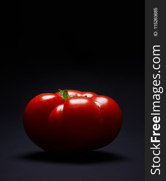 Ripe red tomato on dark background