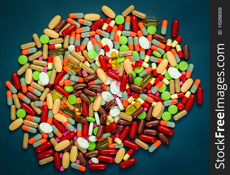 Pile of colorful tablets and capsules pills on blue background. Antibiotic resistance and drug use with reasonable concept. Pharmaceutical industry. Global healthcare. Drug interactions concept