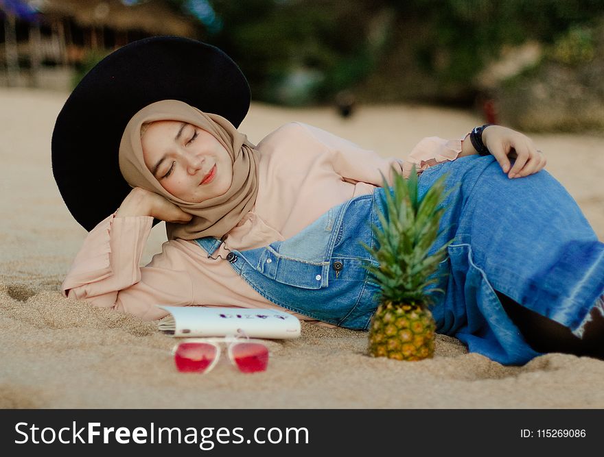 Woman in Blue Denim Dungaree Lying on Sand