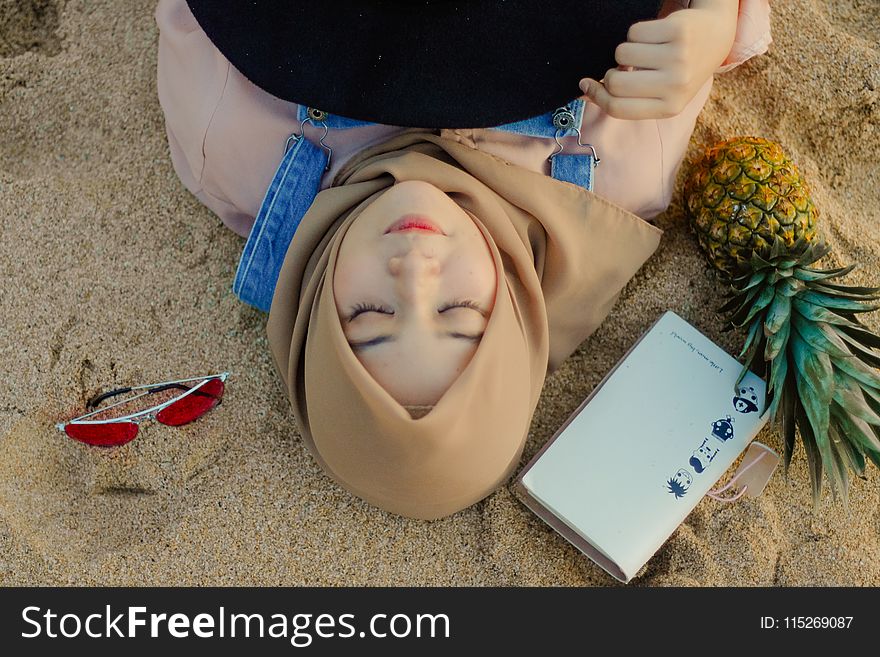 Woman Lying on Sand Beside Sunglasses