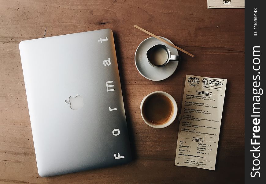 Photo Of Macbook Near Cup And Saucer