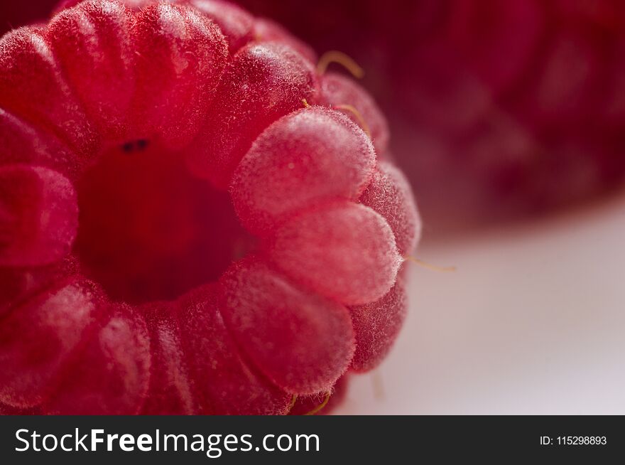 big fresh juicy raspberries on a white saucer close up, macro photo, selected focus