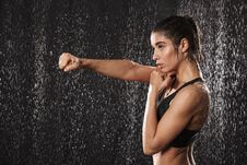 Photo In Profile Of Focused Athletic Woman Wearing Black Sportive Bra Punchning With Clenched Fist, Isolated Over Rain Drops Back Royalty Free Stock Photography Photo In Profile Of Focused Athletic Woman Wearing Black Sportive Bra Punchning With Clenched Fist, Isolated Over Rain Drops Back Royalty Free Stock Photography