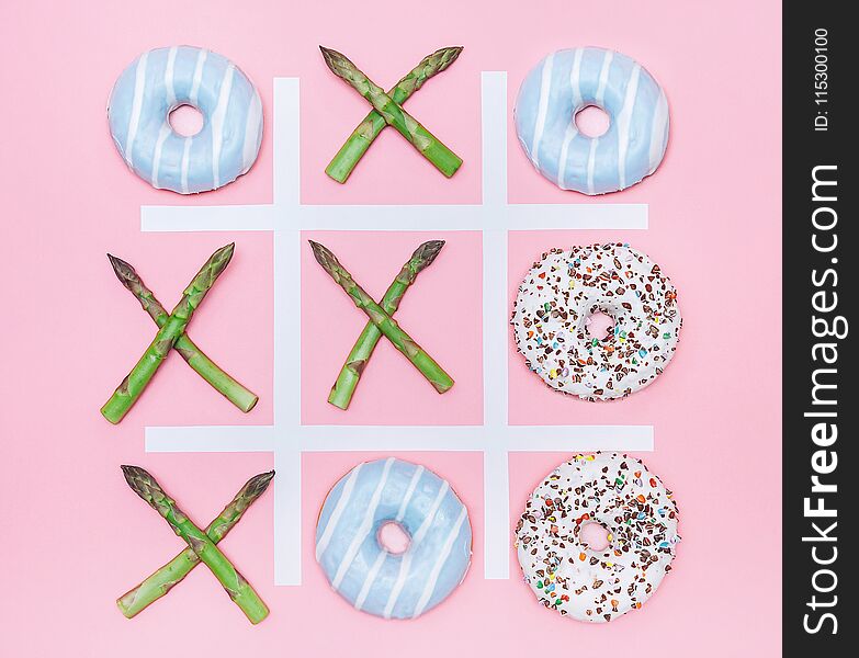 Tik tak toe game with donuts and asparagus. Health nutrition concept image