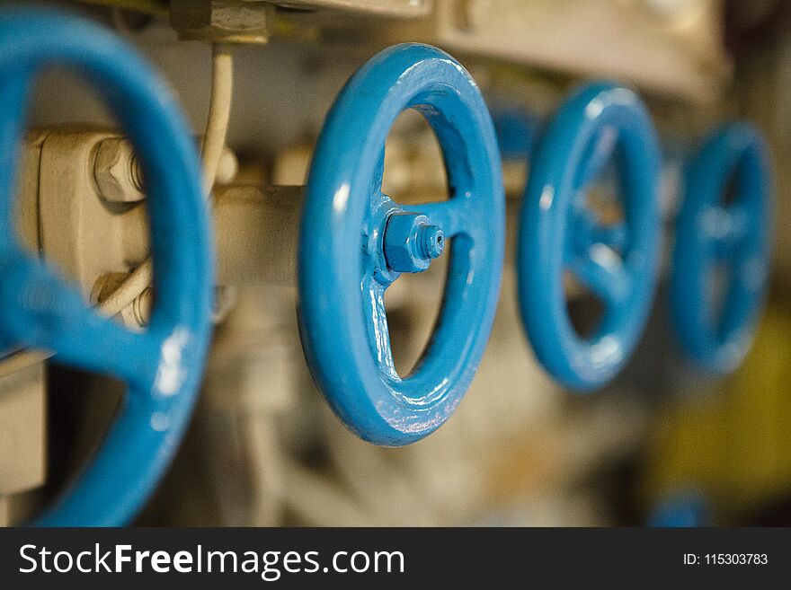 Closeup of blue metal valves on engineering construction