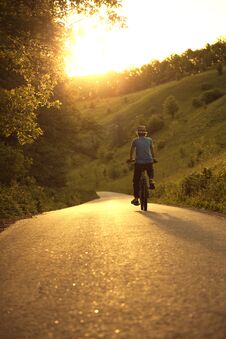 Teenager Riding A Bicycle On The Road Summer Sunlit Royalty Free Stock Photos