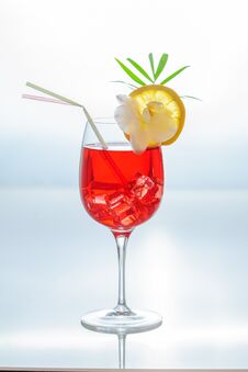 Colorful Summer Tropical Cocktail In A Glass With Ice Cubes, Couple Of Straws, , Slice Of Lemon And A Tropical Plants. Royalty Free Stock Images