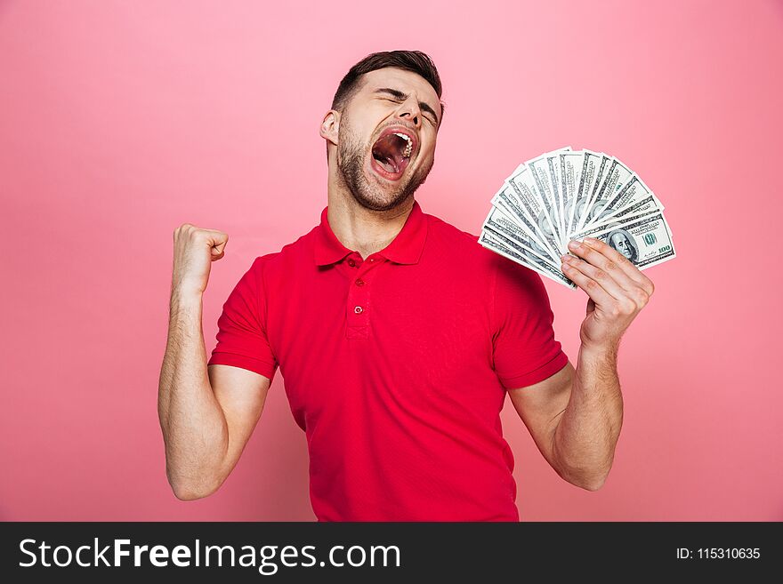 Portrait of a satisfied young man holding money banknotes