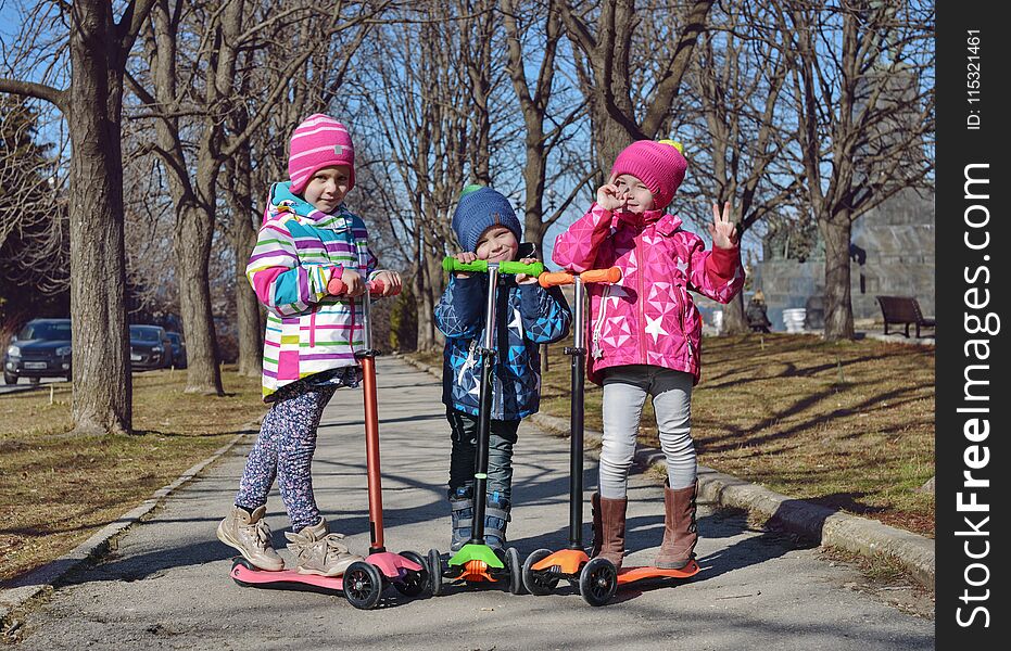 Treee children on the scooters in the park