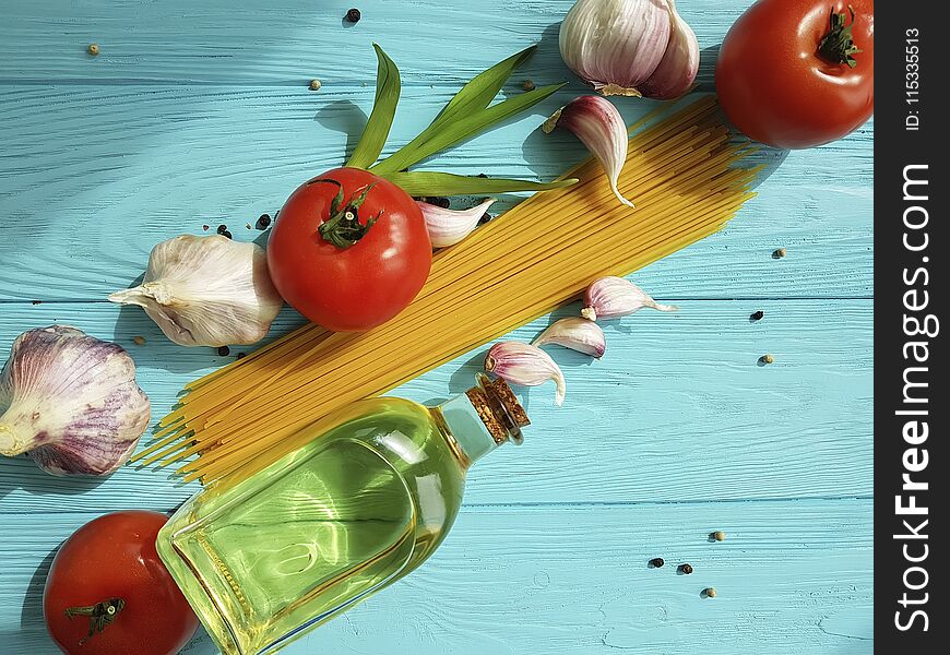 Spaghetti dried tomato garlic, pepper, oil on a blue wooden background