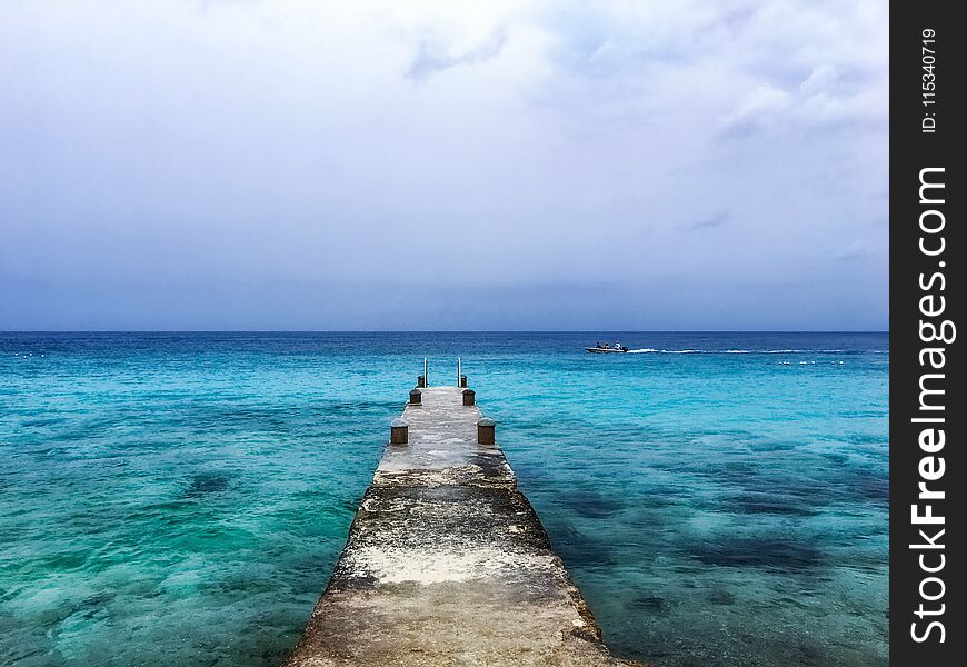 Old pier leading out to the turquoise blue water of the Caribbean sea. Old pier leading out to the turquoise blue water of the Caribbean sea