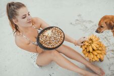 Woman Siting On The Sand With Banana Cake Stock Photo