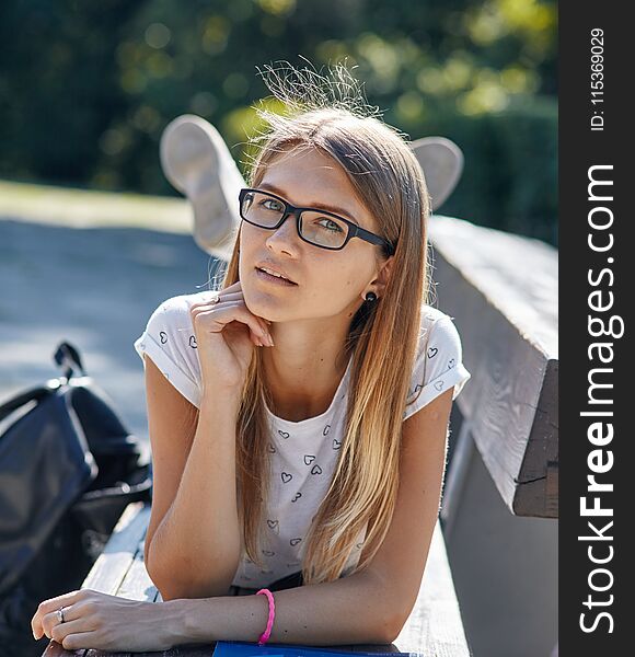 Portrait of student girl. She relaxes on the bench