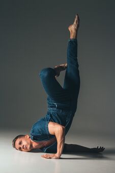 Free The Guy Is Dancing, The Pose Of The Leg Is Up, Face To The Floor, Hands Are Lying On The Floor, On A Faded Background In A Denim S Stock Photography - 115373992