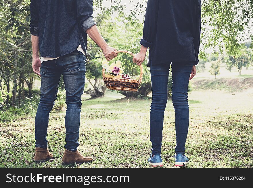 Couple in love walking and holding a picnic basket on nature out