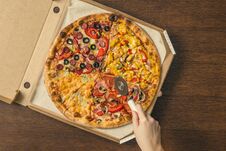 The Girl`s Hands Cut A Huge Pizza In A Box. Four Pizzas In One Royalty Free Stock Photo