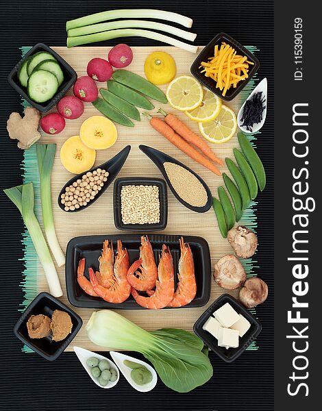 Macrobiotic diet food with seafood, wasabi paste and nuts, tofu, miso, legumes, seaweed, grains, fruit and vegetables with foods high in protein, fiber, antioxidants, minerals and vitamins. On bamboo background, top view. Macrobiotic diet food with seafood, wasabi paste and nuts, tofu, miso, legumes, seaweed, grains, fruit and vegetables with foods high in protein, fiber, antioxidants, minerals and vitamins. On bamboo background, top view.