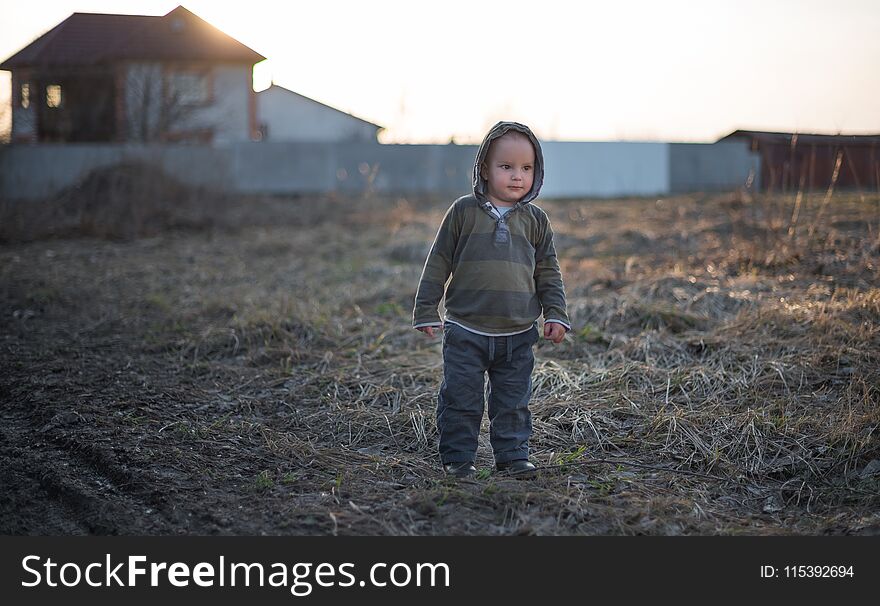 The little two-year-old boy walks outdoors. The little two-year-old boy walks outdoors