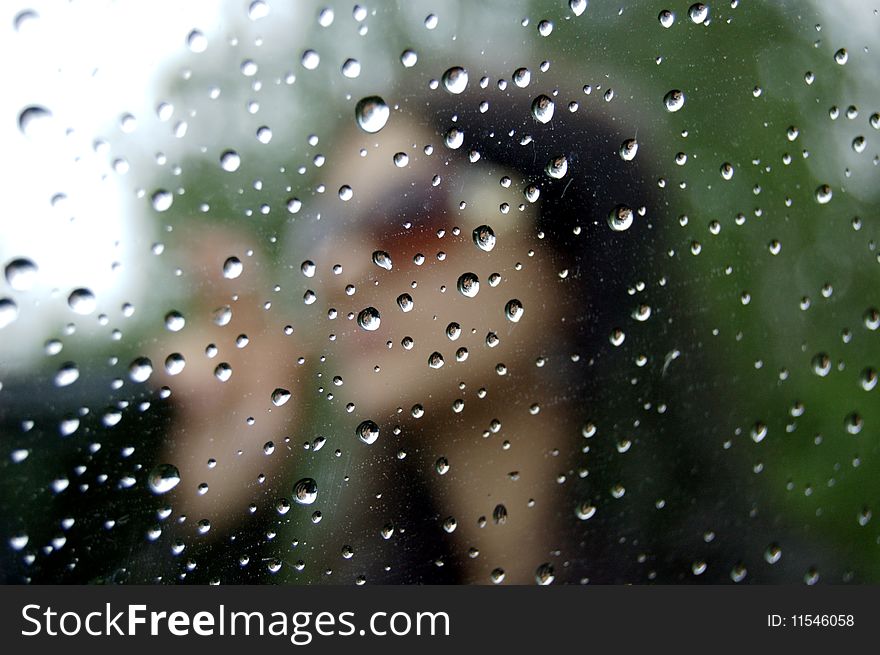 Portrait of the women through wet glass. Portrait of the women through wet glass