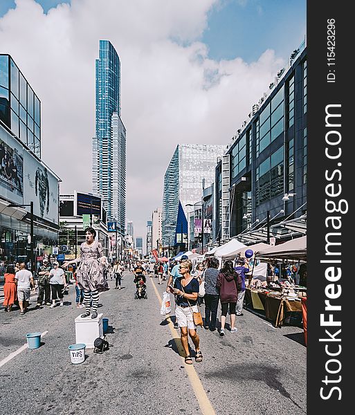 People in the Middle of the Street Under Blue Cloudy Skies