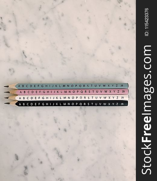 Photo of Four Pencils on Marble Tiles