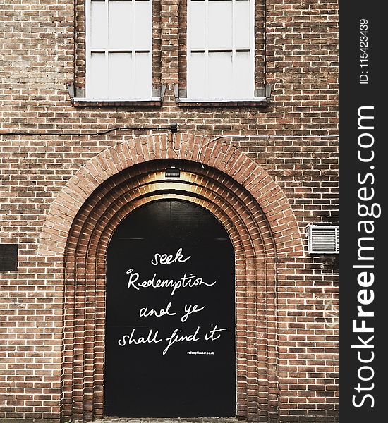 Black Wooden Door With Quote Printed at Daytime