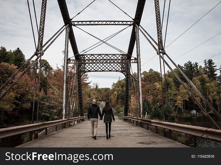 Couple Walking on Gray Bridge at Daytime