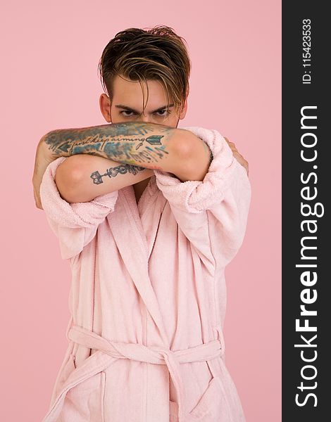 Man Wearing White Bathrobe Stands Near Pink Wall