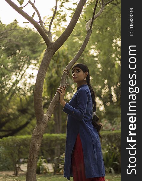 Woman Wearing Blue and Red Long-sleeved Dress Near Tree