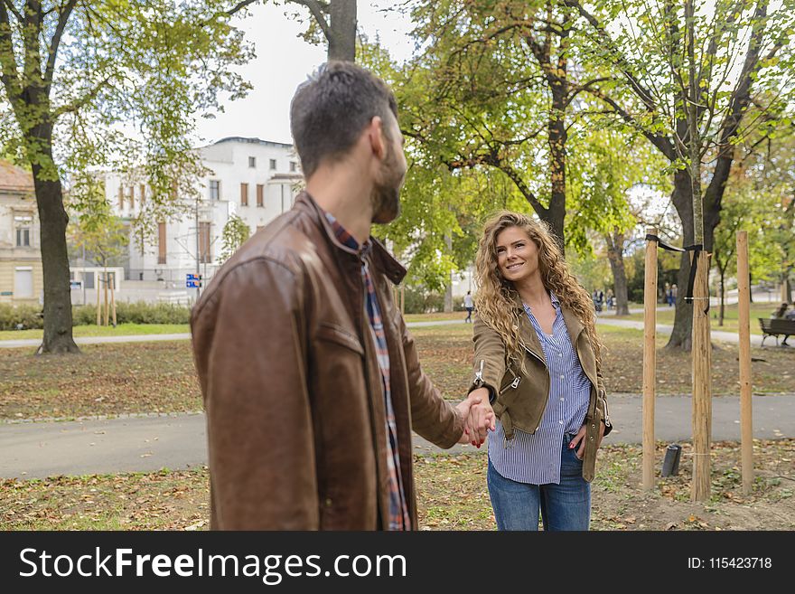 Man Holding Woman&x27;s Hand Near Trees