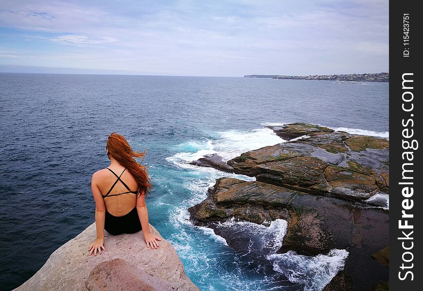 Woman Wearing Monokini on Rock Cliff Near Body of water