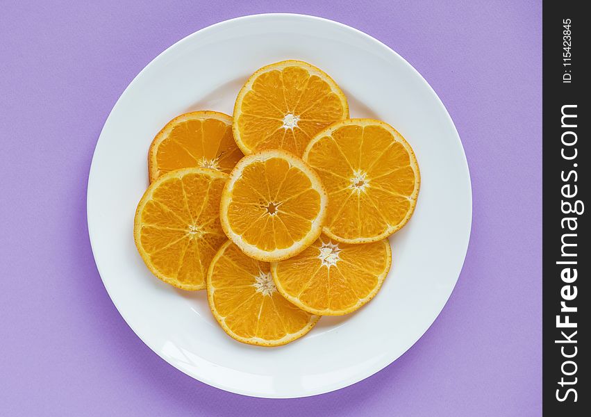Sliced Orange Fruits on Round White Ceramic Plate