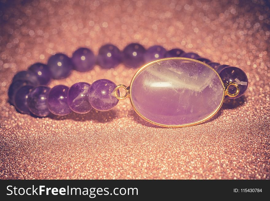 Fashion bracelet made of natural purple amethyst beads, filtered background. Fashion bracelet made of natural purple amethyst beads, filtered background.