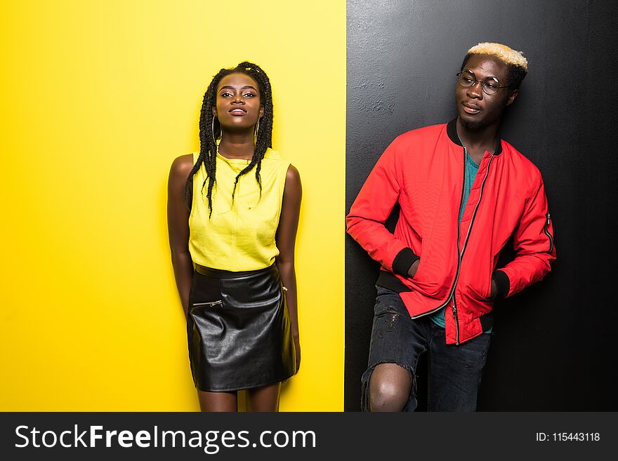 Young and happy afro american couple isolated on color background. Man and woman afro american have fun isolated on yellow and bla