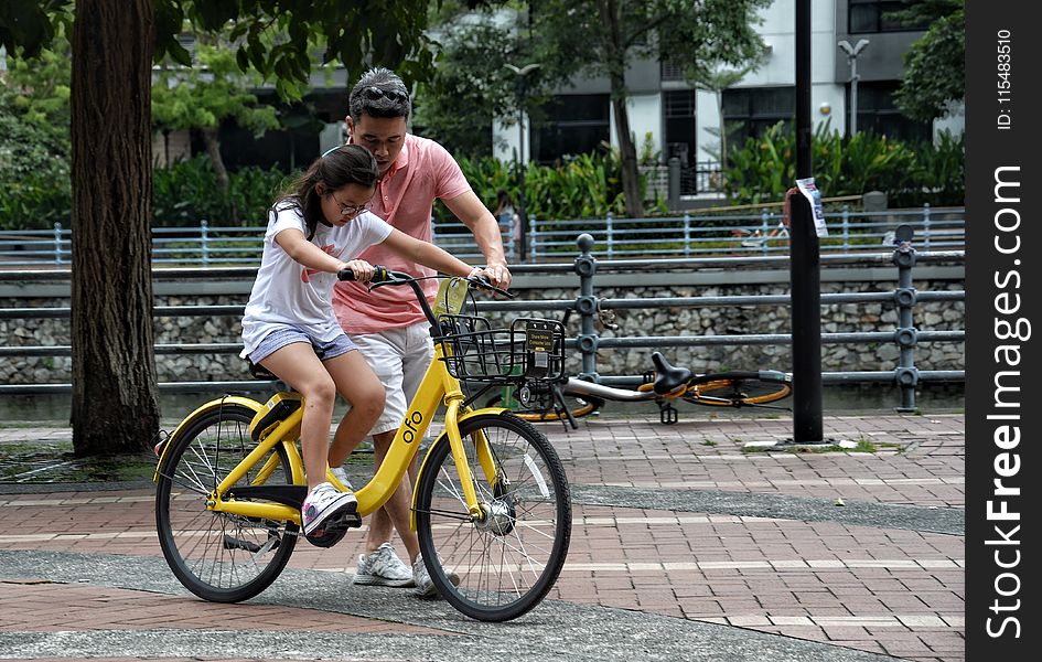 Photography of Girl Riding Bike Beside Man