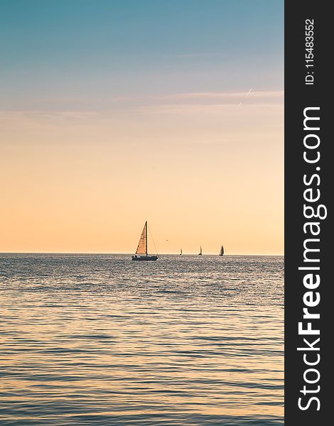 Beige Sailboat Under Clear Skies