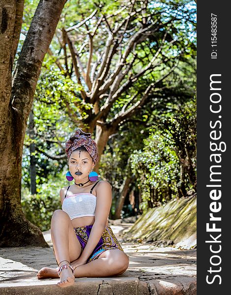 Woman Wearing White Crop Top Sitting on Concrete Floor Near Tree