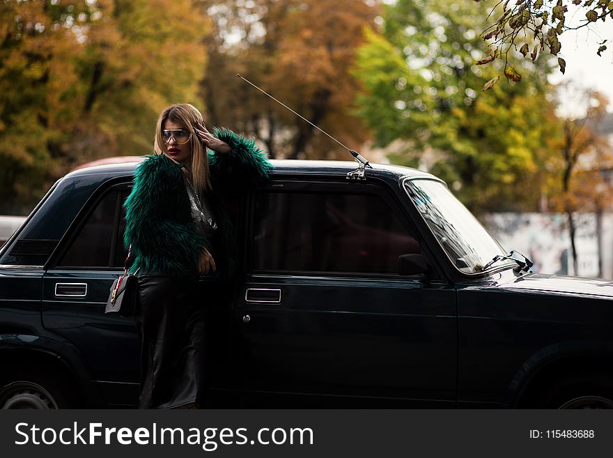 Woman Leaning on Car Surrounded Trees