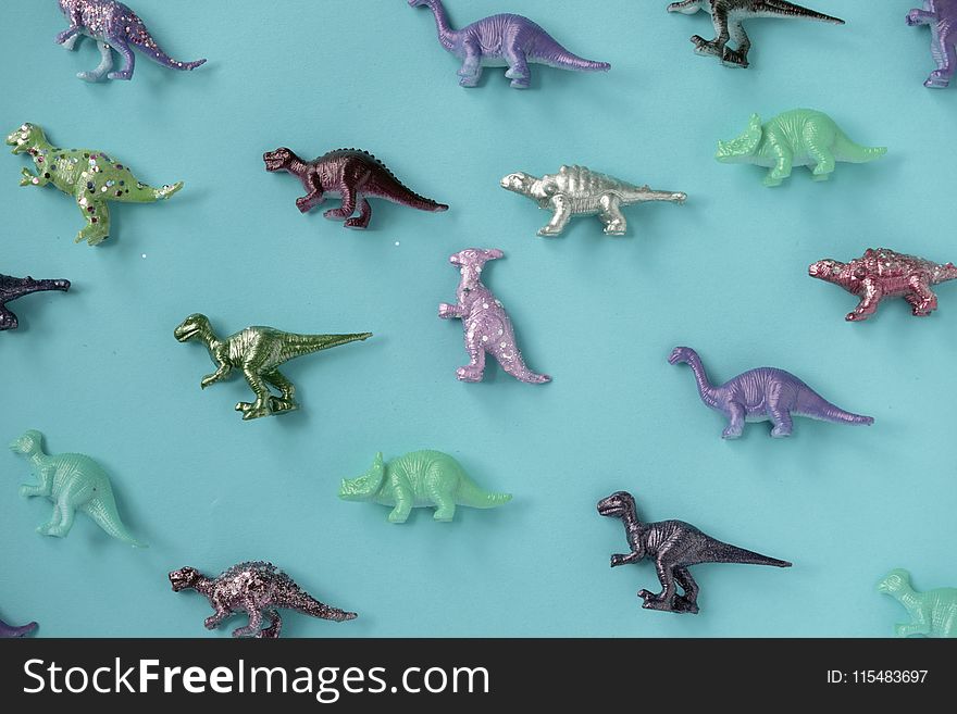 Assorted-color Plastic Dinosaur Figurine Lot on Teal Surface