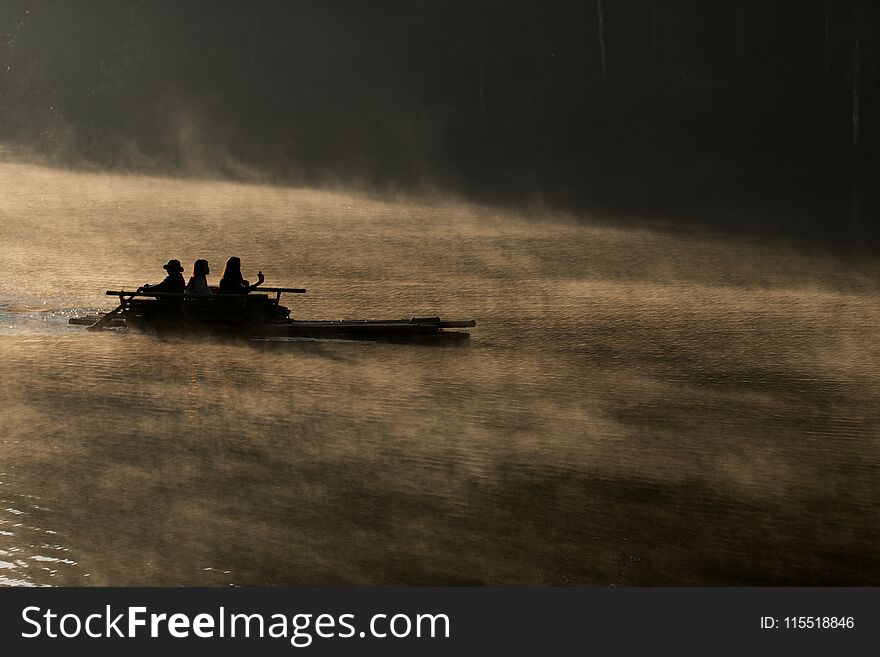 Silhouette of bamboo rafting on the lake in morning