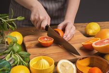 Free Female Hands Cutting Citrus Fruits On Wooden Board Stock Image - 115524871