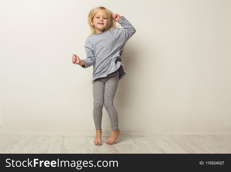 Beautiful casual little girl posing at white studio background. Full-length portrait of cute happy jumping kid, copy space. Beautiful casual little girl posing at white studio background. Full-length portrait of cute happy jumping kid, copy space