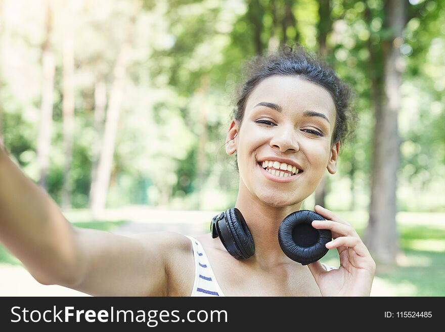 African-american woman taking selfie in park