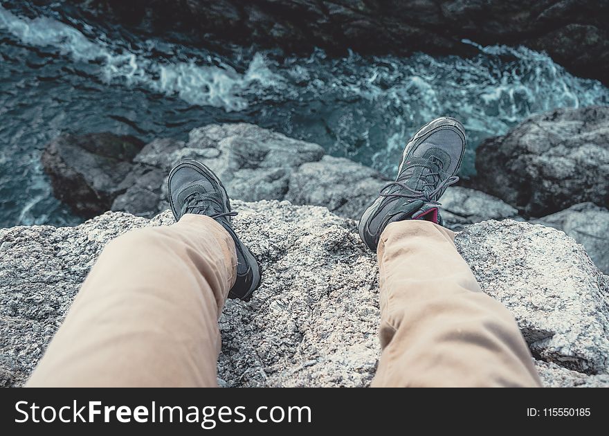 Photo of Man Sitting on the Cliff