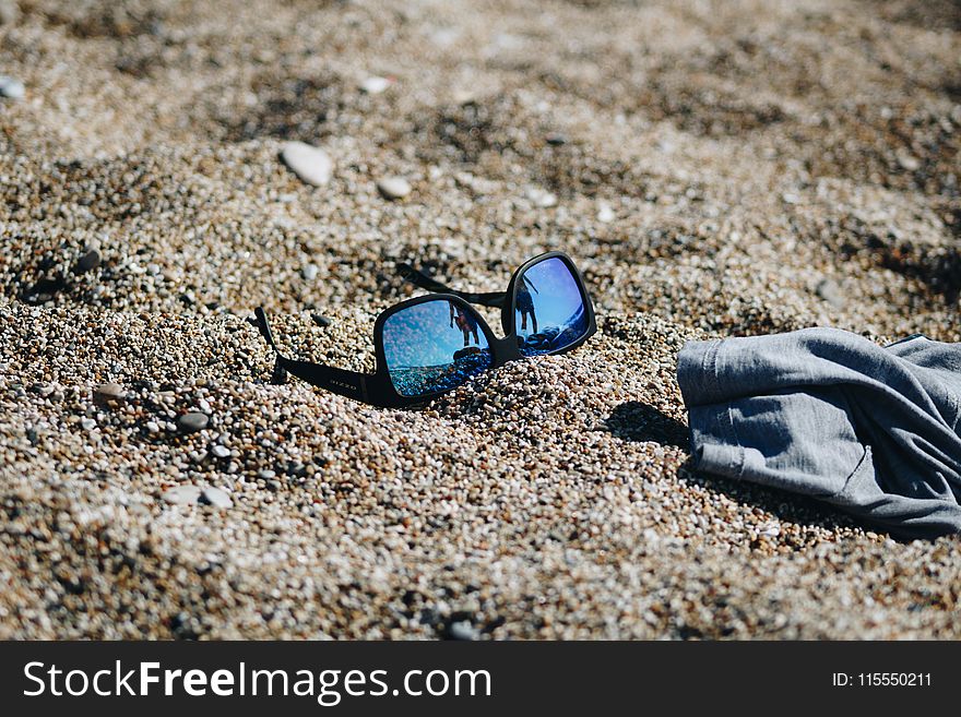Close-Up Photography of Sunglasses on Sand