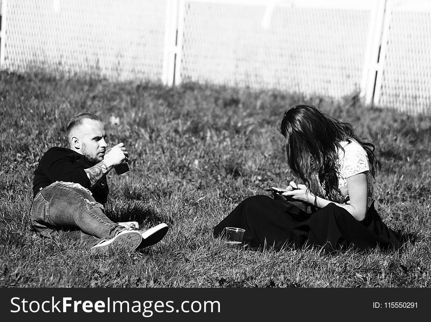 Grayscale Photography of Man and Woman on Grass