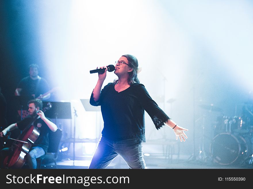 Woman Holding Microphone While Singing On Stage