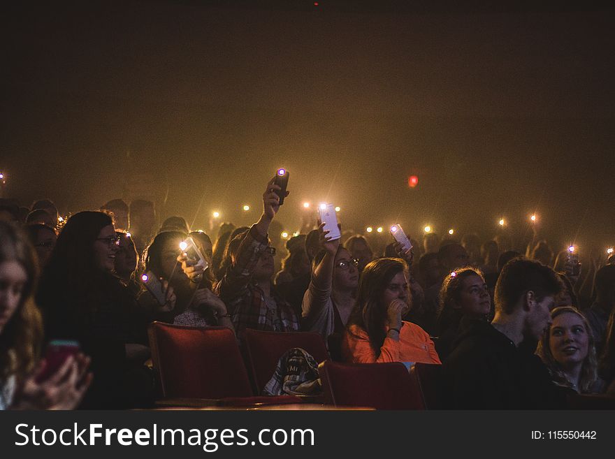 Photo of People Holding Smartphones With Flashlight