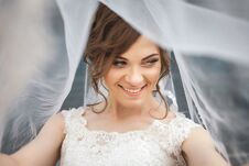 Portrait Of Young Smiling Bride With Veil Over Her Face. Royalty Free Stock Image